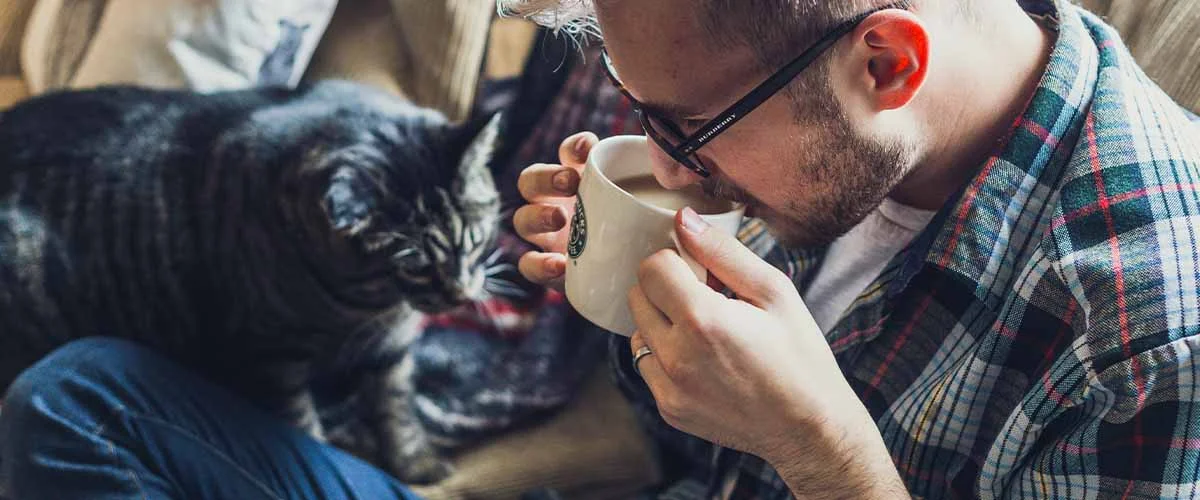 man with cat drinking coffee